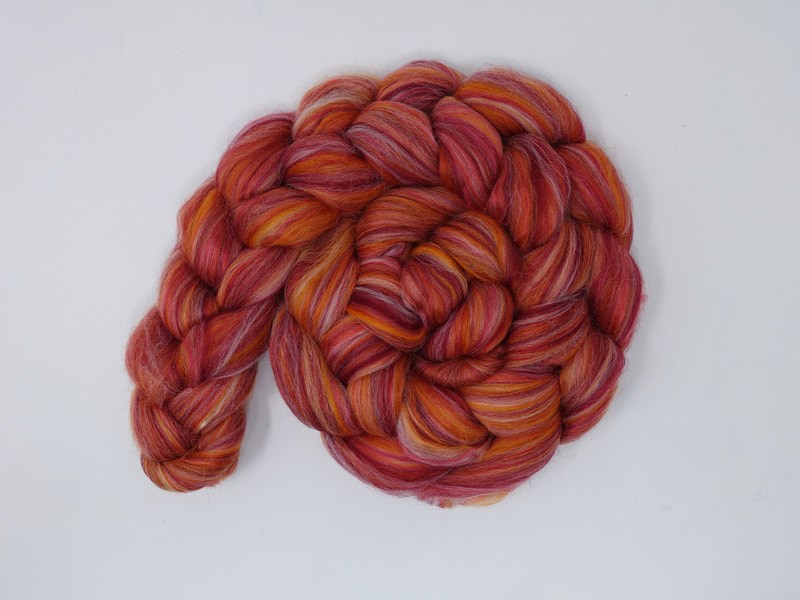 A braid of fibre with streaks of Red, Pink, Orange and White