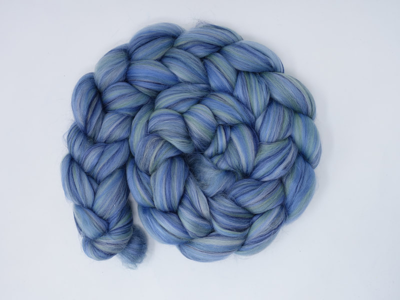 Variegated pale blue fibre with streaks of navy, white and teal.