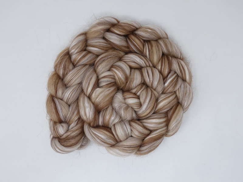 A braid of fibre with streaks of brown, and cream. 