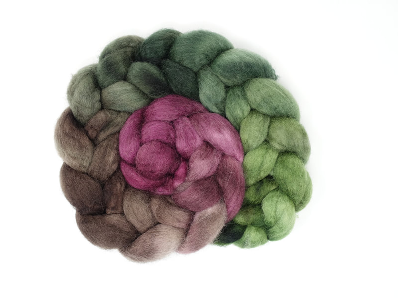 A braid of gradient dyed fibre that transitions from magenta-purple to brown, to forest green to grass green. 