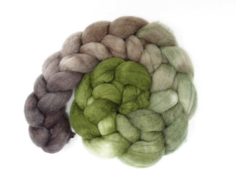 A gradient dyed braid of fibre that transitions from grass green, to pale green to brown. 