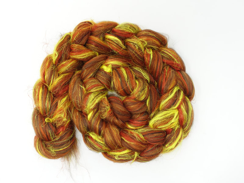 A spiral of combed wool top. The fibre is dark red-orange with bright streaks of lemon yellow. 