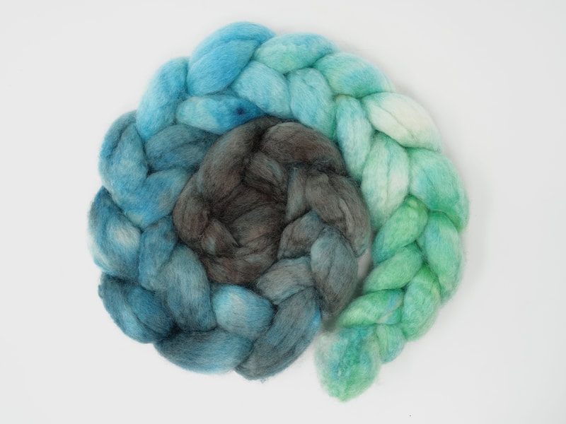 A braid of fibre that transitions from brown to turquoise to aqua to mint green.